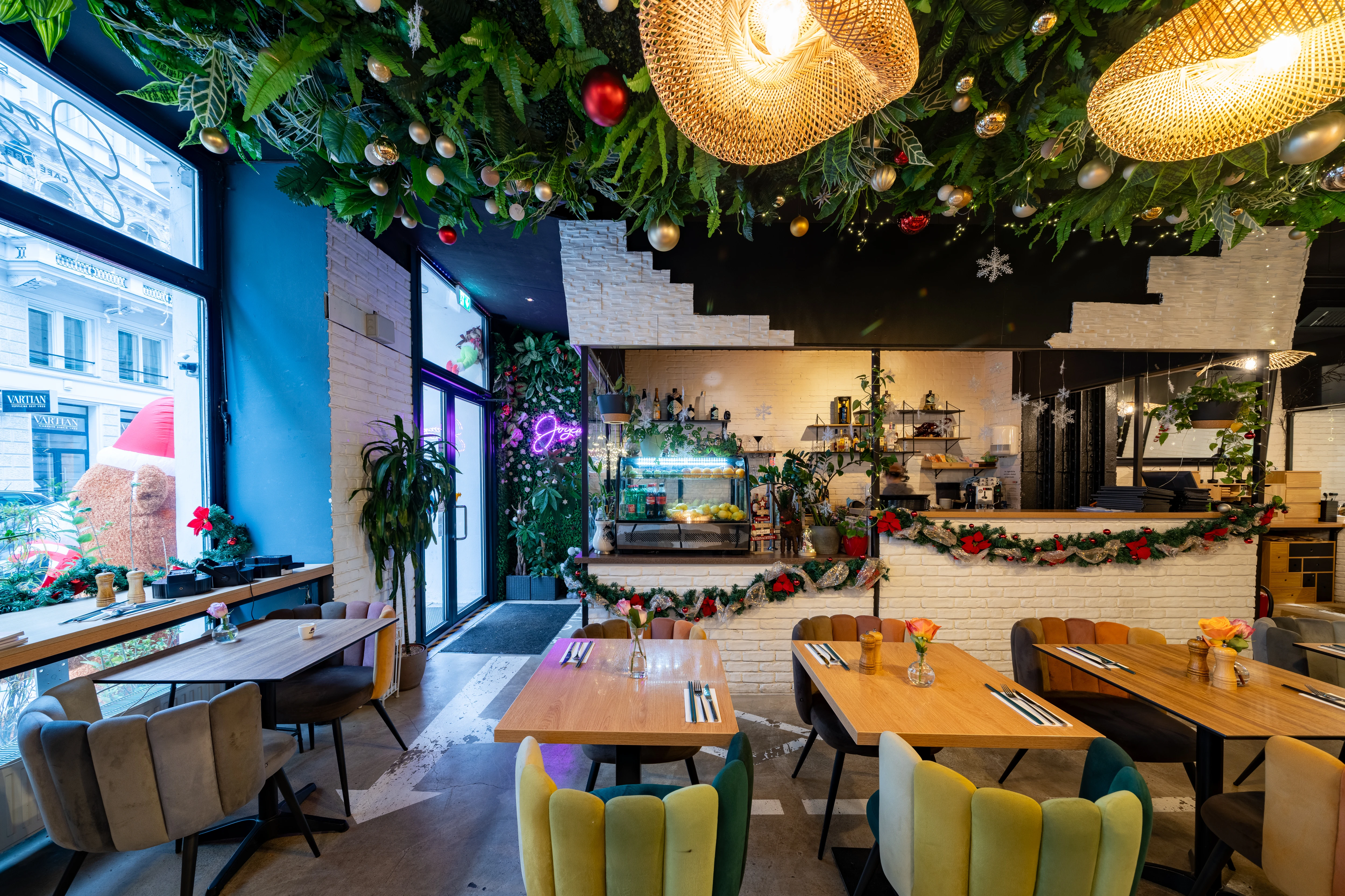 Weihnachtlich dekoriertes Café/Restaurant mit festlich gedeckten Tischen und Weihnachtsschmuck.